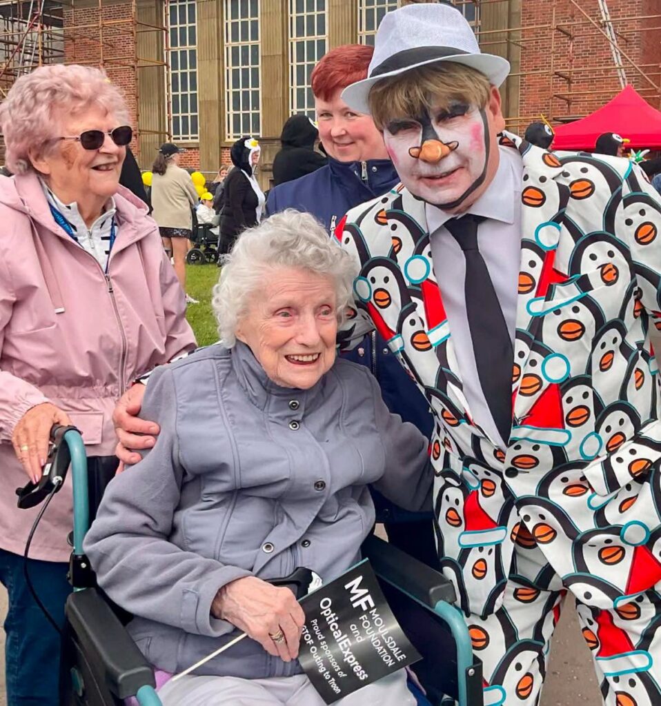 a man in a suit and face paint posing with an older lady