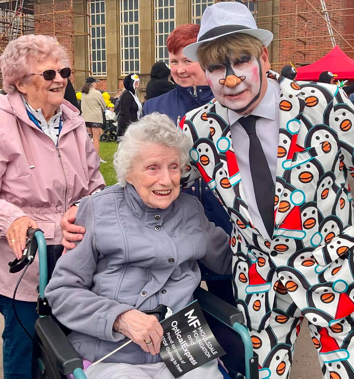 a man in a suit and face paint posing with an older lady