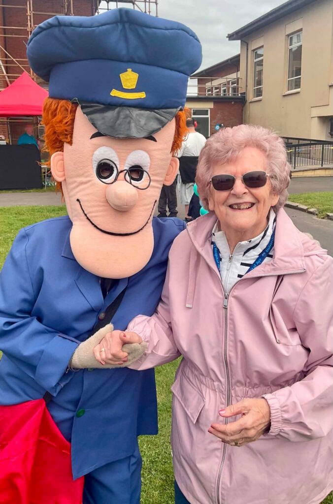 older lady with a postman mascot